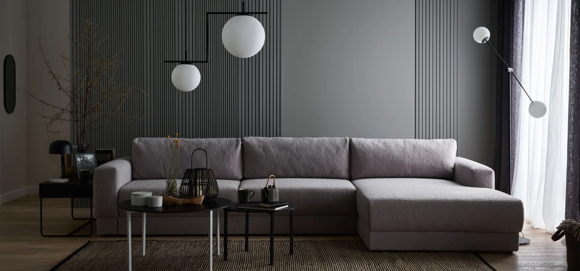Elegancki salon w odcieniach szarości z grafitową ścianą lamelową i minimalistycznym oświetleniem.